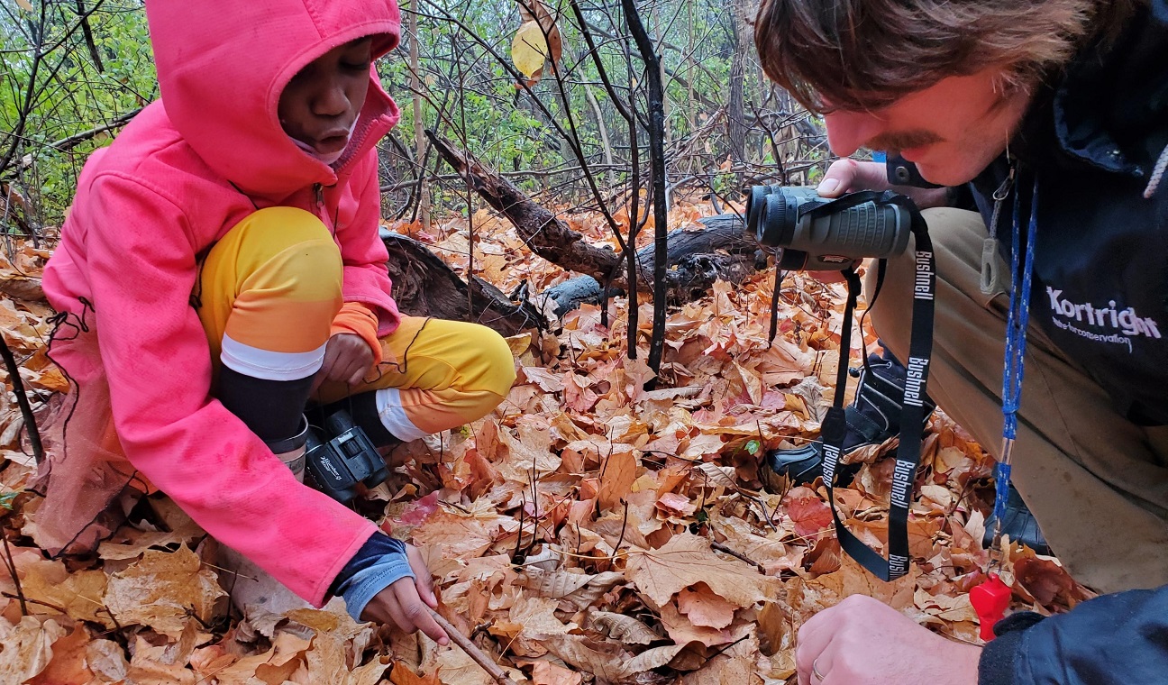 a homeschool at Kortright Centre for Conservation searches for owl pellets among the fallen leaves