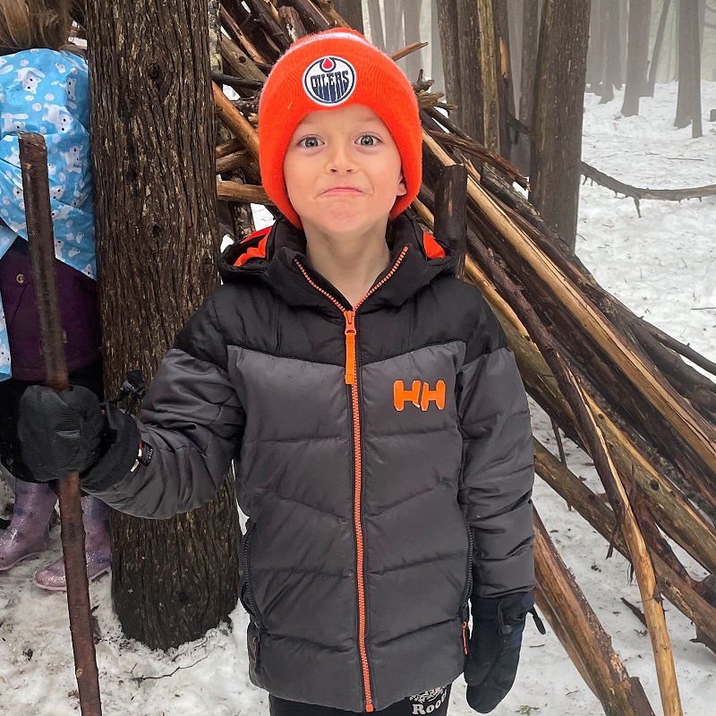 a student learns how to build a shelter at an outdoor winter camp at Kortright Centre